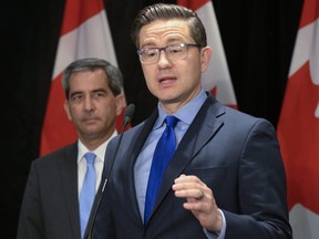 Le chef conservateur Pierre Poilievre prend la parole lors d'une conférence de presse, le mardi 23 mai 2023 à Québec.  Le député conservateur Pierre Paul-Hus, à gauche, regarde.