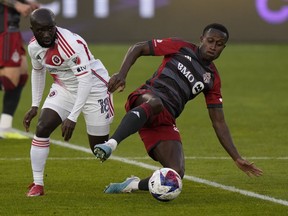 Le milieu de terrain du Toronto FC Richie Laryea (22 ans) va au sol pour contrôler le ballon alors que le milieu de terrain de la New England Revolution Ema Boateng (18 ans) défend pendant la première mi-temps de l'action de football MLS à Toronto le samedi 6 mai 2023.