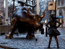 Une statue d'une jeune fille face au mur Saint Bull dans le quartier financier de New York.