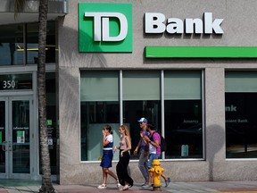 Des gens passent devant une succursale de la Banque Toronto-Dominion à Miami Beach, en Floride.