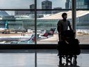 Un voyageur à l'aéroport Pearson de Toronto passe devant des avions d'Air Canada.