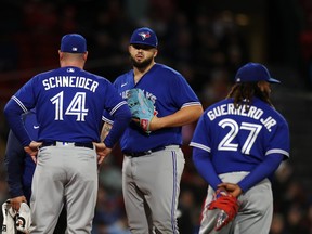 Le gérant John Schneider # 14 des Blue Jays de Toronto vérifie le lanceur Alek Manoah # 6 après avoir été touché par une balle en fin de quatrième manche contre les Red Sox de Boston au Fenway Park.