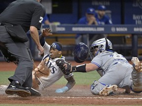 L'arbitre du marbre Jordan Baker regarde le receveur des Blue Jays Alejandro Kirk, à droite, marquer Rays 'Wander Franco, qui tentait de marquer du troisième but sur un lancer du voltigeur du centre de Toronto Kevin Kiermaier lors de la cinquième manche le lundi 22 mai 2023 , à Saint-Pétersbourg, en Floride.