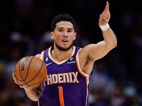 Le gardien des Phoenix Suns Devin Booker (1) contrôle le ballon lors d'un match éliminatoire.