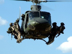 Des troupes canadiennes du Régiment d'opérations spéciales du Canada (ROSC) se préparent à descendre en rappel d'un hélicoptère CH-146 Griffon lors d'un exercice d'entraînement près de Kamloops, en Colombie-Britannique.