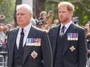 Le prince britannique Andrew, devant, et le prince Harry suivent le cercueil de la reine Elizabeth II lors d'une procession du palais de Buckingham au Westminster Hall à Londres, le mercredi 14 septembre 2022. 