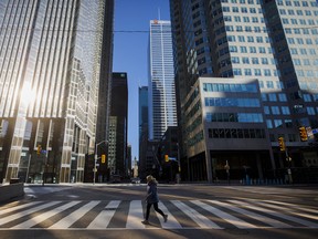 Un piéton traverse la rue dans le quartier financier de Toronto.  Les prêteurs semblent travailler avec leurs clients pour éviter des faillites coûteuses.