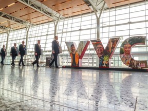 Les pilotes de WestJet traversent l'aéroport international de Calgary avant un piquet d'information le 8 mai.