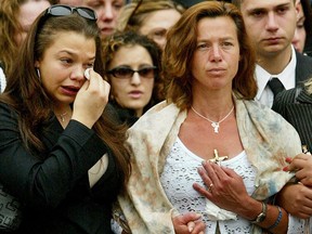 Maria Jones (à droite), la mère de Holly Jones, 10 ans, assassinée, écoute avec sa fille Natasha, 17 ans (à gauche) pendant qu'une chanson est jouée pendant les funérailles de Holly à l'église catholique romaine St. Vincent de Paul à Toronto, Mardi 20 mai 2003.