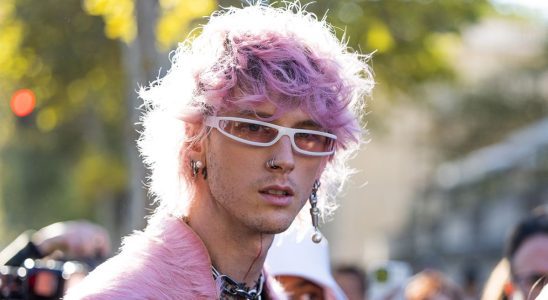 Machine Gun Kelly with pink hair wearing faux pink fur.