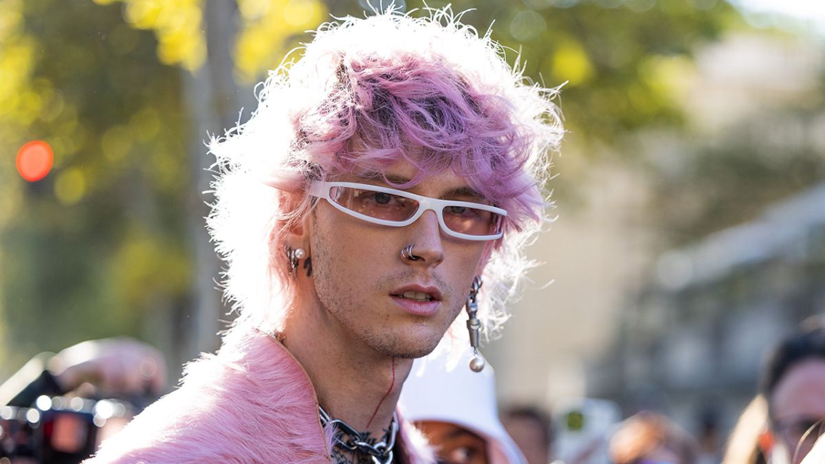 Machine Gun Kelly with pink hair wearing faux pink fur.