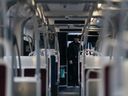 Un policier se tient à l'intérieur d'un tramway de la TTC sur l'avenue Spadina à Toronto.