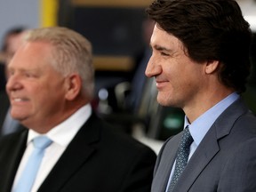 Le premier ministre Justin Trudeau et le premier ministre de l'Ontario Doug Ford réagissent lors d'une conférence de presse pour annoncer les détails de la construction d'une giga-usine de production de batteries pour véhicules électriques par Volkswagen.