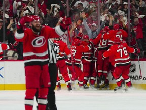 L'ailier droit des Hurricanes de la Caroline Jesper Fast (71 ans) est félicité par ses coéquipiers après son but gagnant contre les Devils du New Jersey.