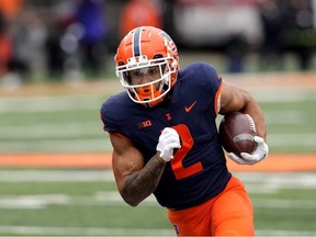 Le porteur de ballon de l'Illinois Chase Brown porte le ballon pendant la première moitié d'un match de football universitaire de la NCAA contre Purdue le samedi 12 novembre 2022 à Champaign, Illinois.