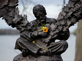 Des fleurs trônent dans les bras de la statue de Gordon Lightfoot à Orillia, en Ontario, après l'auteur-compositeur-interprète canadien cette semaine à l'âge de 84 ans.