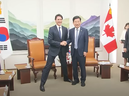 Une capture d'écran d'un rapport de l'agence de presse sud-coréenne Yonhap montrant le premier ministre Justin Trudeau adoptant une position inhabituellement large tout en posant avec le président de l'Assemblée nationale coréenne Kim Jin-pyo.