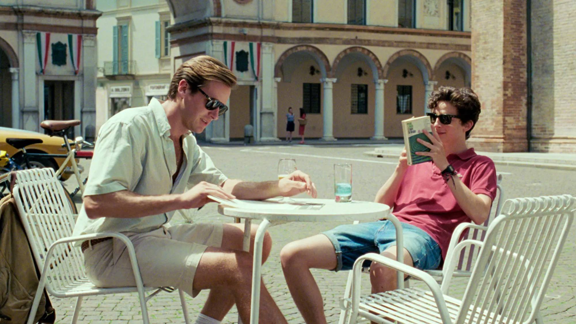 Armie Hammer et Timothee Chalamet sont assis à une table dans Call Me by Your Name