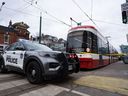 Des voitures de police entourent un tramway de la TTC sur l'avenue Spadina, à Toronto, le mardi 24 janvier 2023 après un incident au couteau.  Alors que les villes canadiennes cherchent des moyens de lutter contre la violence dans les transports en commun, les experts affirment que des stratégies au sud de la frontière qui combinent l'application de la loi, les soutiens sociaux et l'engagement communautaire pourraient offrir de nouvelles solutions au problème.