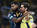 Mahendra Singh Dhoni (à droite) des Super Kings de Chennai et Hardik Pandya des Titans du Gujarat font un geste pendant le lancer avant le début de leur match.