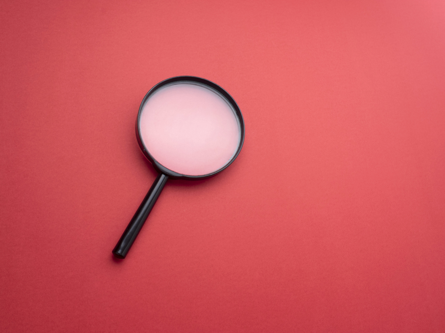 Loupe sur fond de couleur rouge.