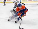 Kailer Yamamoto (56 ans) des Oilers d'Edmonton, patine dans le coin avec Quinton Byfield des Kings de Los Angles à Rogers Place à Edmonton le 30 mars 2023. Photo de Shaughn Butts-Postmedia