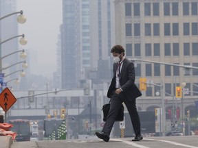 Un homme se rend au travail avec un masque près de la Colline du Parlement