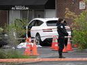 La police de Montréal monte la garde à côté du corps d'une femme tuée par balle dans sa voiture mardi à Côte-des-Neiges.  La voiture a roulé dans un bâtiment après la fusillade et des trous de projectiles ont été trouvés dans la vitre latérale.