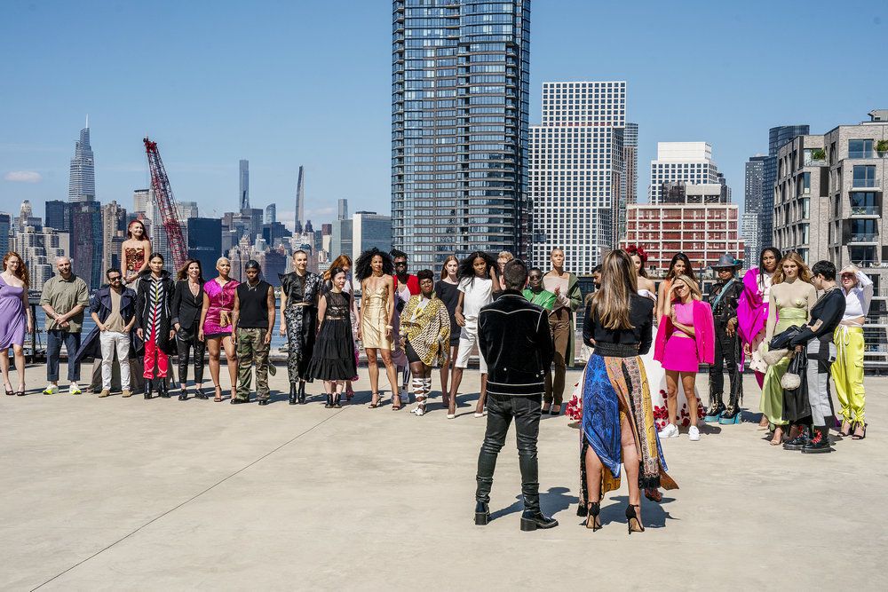 Le casting de Project Runway saison 20 standa nd écoute les hôtes devant un horizon new-yorkais