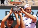 Le Japonais Miyu Kato (à gauche) et l'Allemand Tim Puetz célèbrent la tenue de leur trophée après avoir remporté la finale du double mixte à l'Open de France.