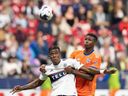 Sergio Cordova des Whitecaps de Vancouver et Yerson Mosquera du FC Cincinnati sautent pour le ballon lors de la première moitié d'un match de football de la MLS à Vancouver, le samedi 10 juin 2023.