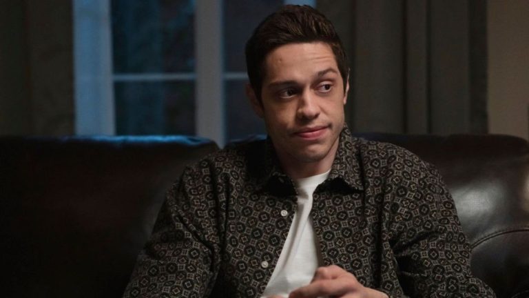 Pete Davidson sitting on a couch in Bupkis.