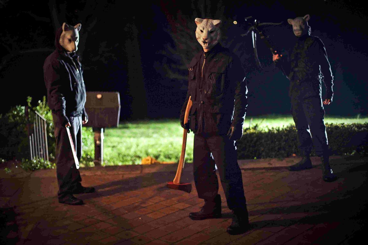 Les tueurs de You're Next se tiennent devant une maison, portant des masques d'animaux et tenant diverses armes