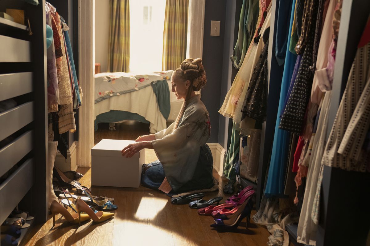 Carrie (Sarah Jessica Parker) assise dans son placard ouvrant une boîte dans une image de And Just Like That... saison 2