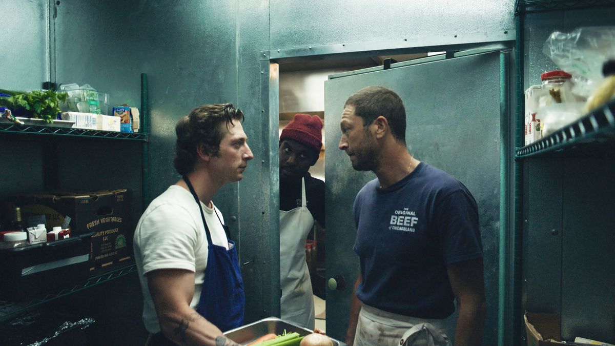 Carmy (Jeremy Allen White) debout dans un réfrigérateur parlant à Richie (Ebon Moss-Bachrach) tandis que Marcus (Lionel Boyce) passe la tête par la porte.