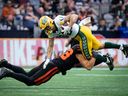 Le secondeur des BC Lions Ben Hladik (46 ans) s'attaque au receveur des Elks d'Edmonton Vincent Forbes-Mombleau (82 ans) lors de la première moitié d'un match de football de la LCF, à Vancouver, le samedi 17 juin 2023.