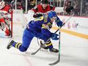 Le Suédois Oskar Pettersson se bat pour se positionner avec l'Autrichien Christoph Tialler au Championnat mondial de hockey junior de l'IIHF.