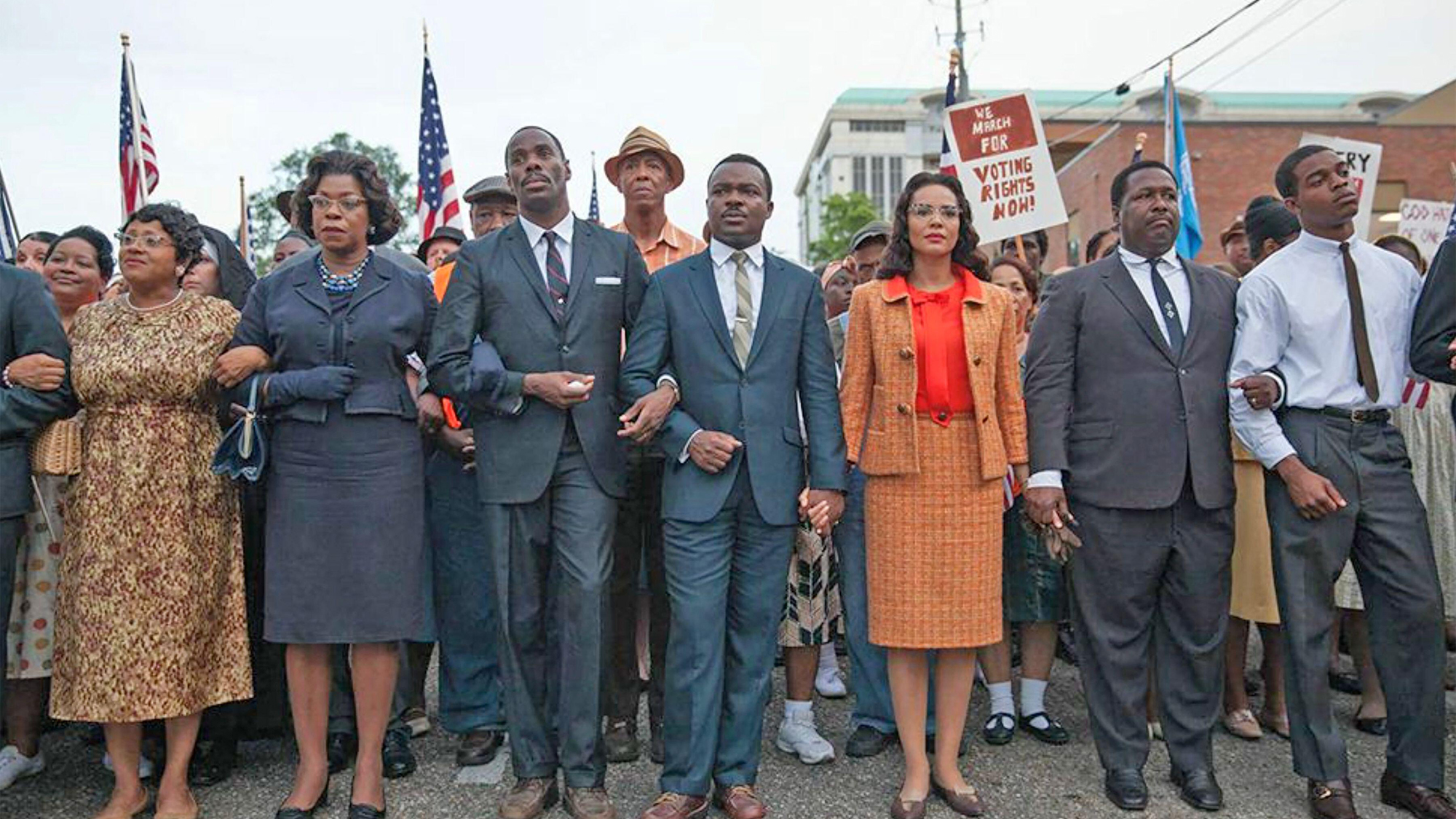 David Oyelowo (au centre) dans le rôle du Dr Martin Luther King à côté de Carmen Ejogo dans le rôle de Coretta Scott King, marchant parmi d'autres hommes et femmes noirs à Selma