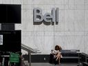 Une femme lit devant un bureau de Bell Canada à Toronto.