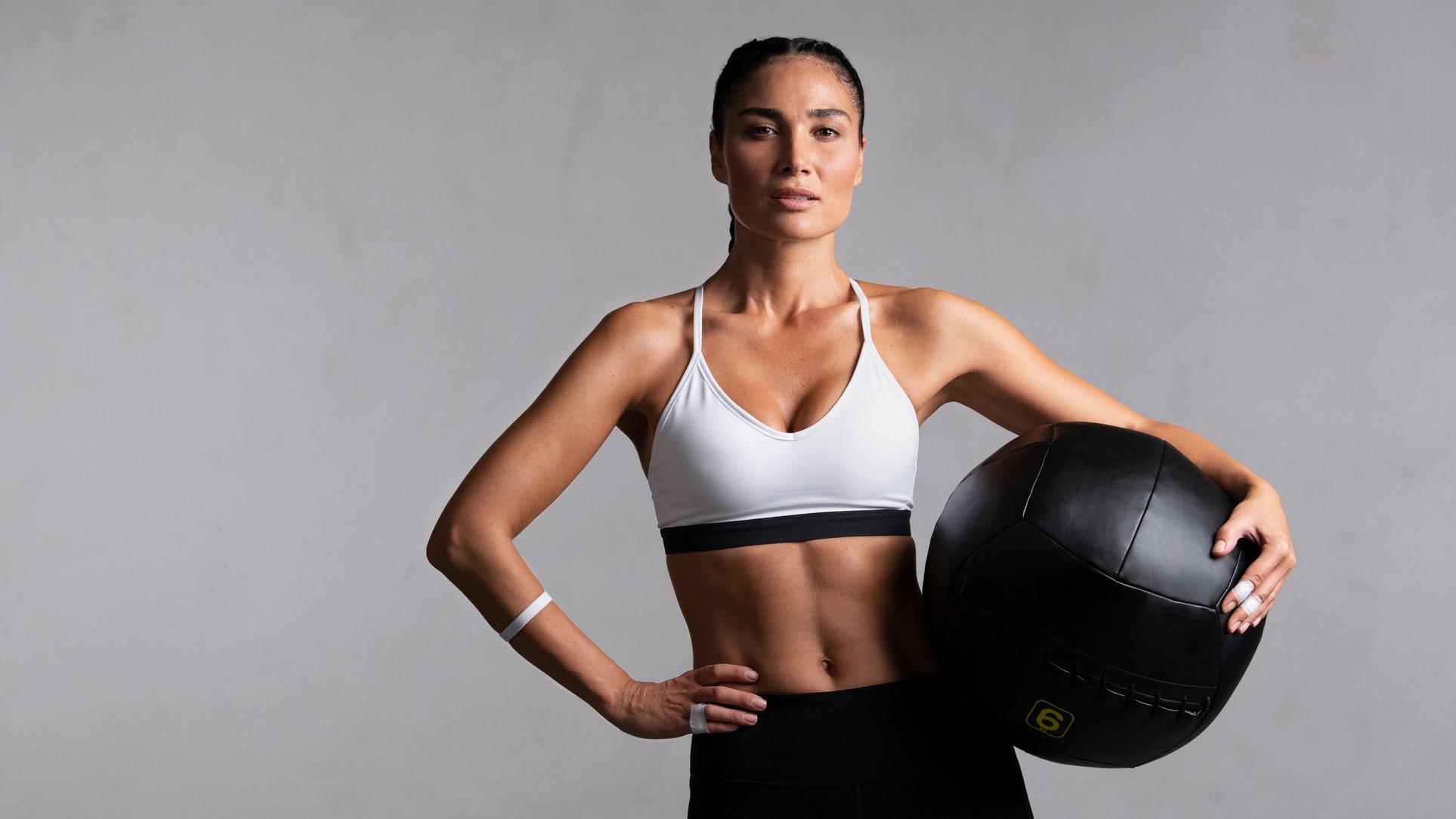 une photo d'une femme avec des abdominaux tenant un médecine-ball