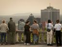 Les gens admirent le site de la ligne d'horizon de Montréal et des montagnes de la Montérégie depuis le belvédère du belvédère Kondiaronk sur le mont Royal le lundi 5 juin 2023. Les incendies de forêt dans le nord du Québec ont recouvert la ville d'une brume orange alors que le smog des incendies s'est abattu la qualité de l'air dans la ville.