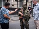 Un habitant local s'entretient avec un membre du groupe Wagner à Rostov-sur-le-Don, le 24 juin 2023. 