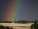 Un chevalet pompe puise du pétrole à la tête d'un puits tandis qu'un arc-en-ciel l'éclaire près de Calgary.  Une nouvelle modélisation de la Régie de l'énergie du Canada suggère que la production pétrolière canadienne chutera d'ici 2050 si le monde atteint des émissions nettes de gaz à effet de serre nulles dans ce délai.