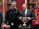 Le premier ministre François Legault, à droite, célèbre avec le directeur général et entraîneur des Remparts de Québec, Patrick Roy, tout en tenant le trophée lors d'une cérémonie le 8 juin à l'Assemblée nationale marquant la victoire de l'équipe à la coupe Memorial.