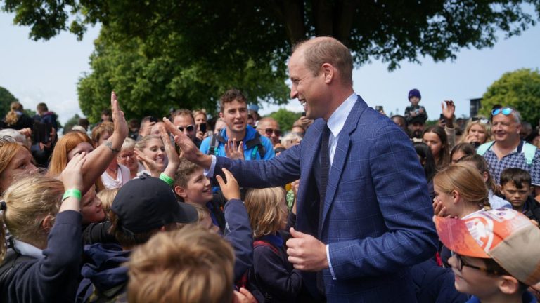 Le prince de Galles fait un high-five aux enfants et présente un trophée de chèvre lors d’une visite pour montrer