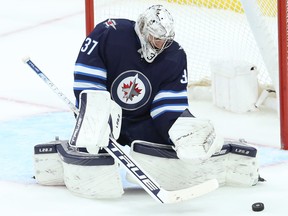 Le gardien des Jets Connor Hellebuyck.  L'enrobage de leurs intentions par les Jets de Winnipeg — se rééquiper plutôt que reconstruire — n'a pas influencé l'esprit de Pierre-Luc Dubois ou de Hellebuyck.