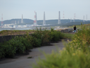 Une femme marche le long d'un chemin vers la centrale nucléaire de Kashiwazaki Kariwa de Tokyo Electric Power Co. (Tepco) dans la ville de Kashiwazaki, préfecture de Niigata, au Japon.