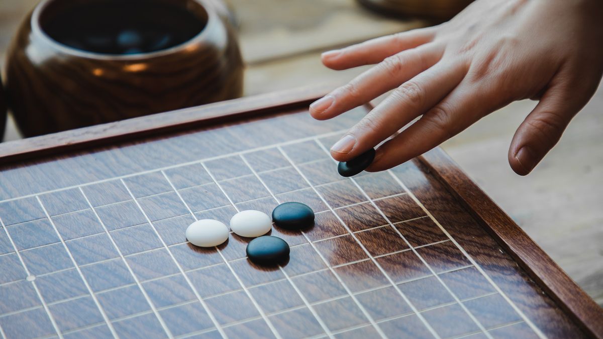 female hand playing the game of go