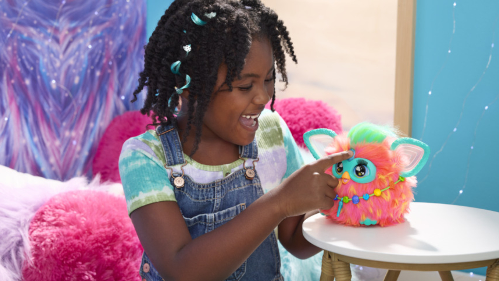 Une petite fille appuie sur le bouton en forme de cœur d'un jouet Furby