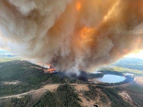 Une colonne de fumée s'élève du feu de forêt EWF031 près de Lodgepole, Alberta, Canada le 4 mai 2023.